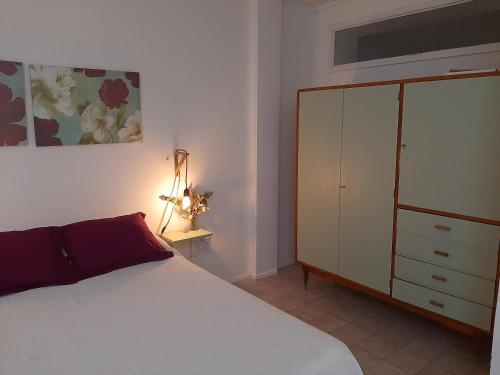 a bedroom with a white bed and a dresser at Departamento Interno Divino! in Balcarce