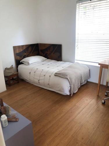 开普敦Bright and tranquil home in beautiful Hout Bay的带床和木地板的卧室