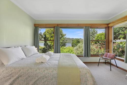a bedroom with a large bed with a large window at Okareka Lakefront in Rotorua
