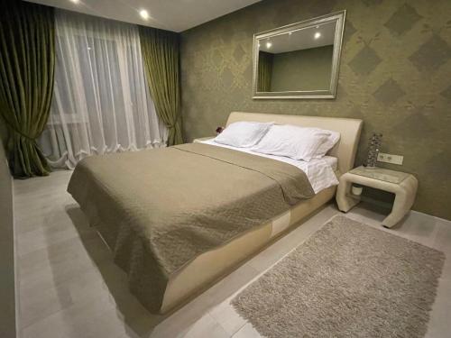 ein Schlafzimmer mit einem Bett mit einem Spiegel und einem Teppich in der Unterkunft Apartment in Šiauliai in Šiauliai
