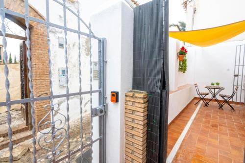 a gate to a balcony with a table and chairs at Carmen Aljibe de la Miel in Granada