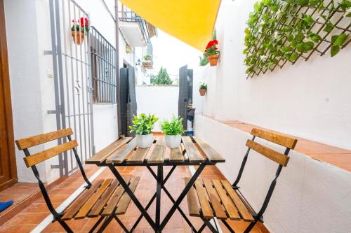 a table and chairs on a balcony with plants at Carmen Aljibe de la Miel in Granada