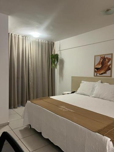 a bedroom with a large bed and a window at FLAT 508 PARTICULAR - HOTEL in Natal