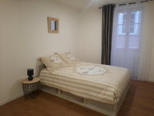 a bed in a room with a window and a bedskirtspectspectspectspects at Le refuge du bonheur in Trévoux