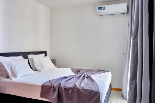 um quarto com uma cama com um cobertor roxo em Lc Apartments - Sunday em Santa Maria