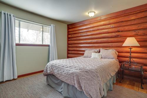 sypialnia z drewnianą ścianą z łóżkiem i oknem w obiekcie Quiet Lander Cabin Rental on Quarter-Acre Land w mieście Lander