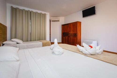 a hotel room with two beds with white towels at Arraial do Sol Beach Hotel in Arraial d'Ajuda