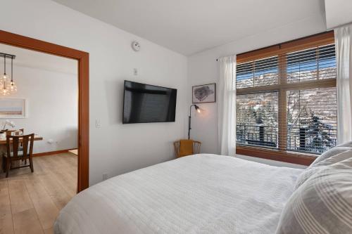 ein weißes Schlafzimmer mit einem Bett und einem Fenster in der Unterkunft Capitol Peak 3317 in Aspen