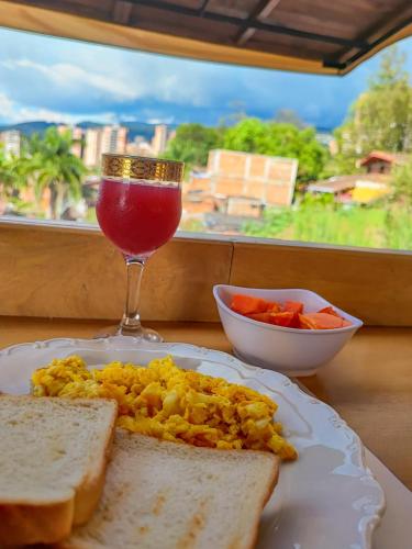 a plate of eggs and toast and a drink at Casa Los Naranjos Hostal in Medellín