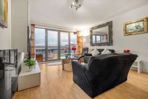 uma sala de estar com um sofá preto e uma mesa em Boutique Quayside Penthouse em Gateshead