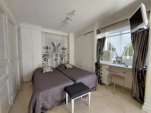 a bedroom with a bed and a desk and a window at Villa spa hamman sauna Piscine 9 chambres in Juan-les-Pins