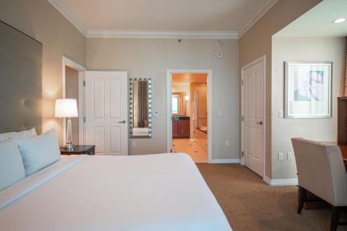 a bedroom with a large white bed and a desk at Jet Luxury Elite at The Signature in Las Vegas
