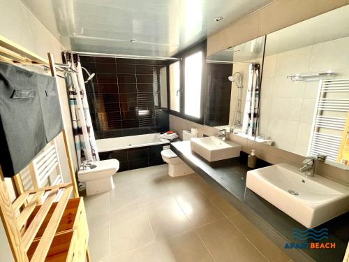 bagno con 2 lavandini, servizi igienici e specchio di APARTBEACH LAS VILLAS de CASTELLVELL a Almoster