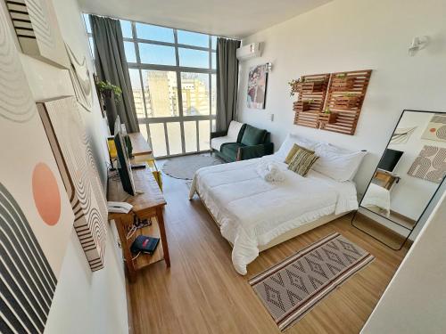 a bedroom with a bed and a living room at Vem pro Copan in Sao Paulo