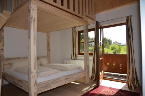a bedroom with a canopy bed with a large window at Berggasthof Steckholzer in Sankt Jodok am Brenner