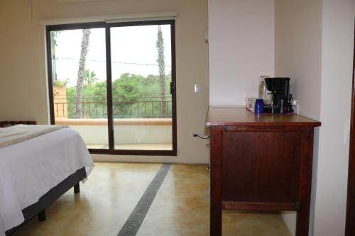 a bedroom with a bed and a dresser and a window at Casa Bugambilias in Todos Santos