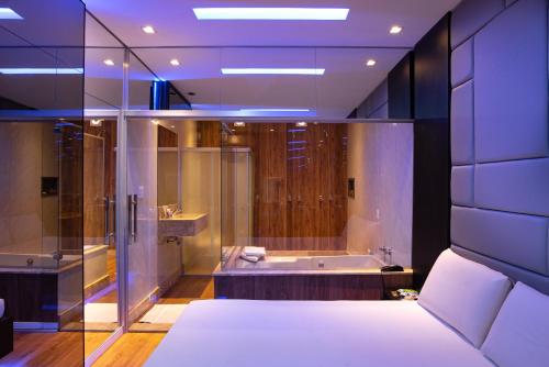 uma grande casa de banho com banheira e chuveiro em Motel Fantasy 1 em Belo Horizonte