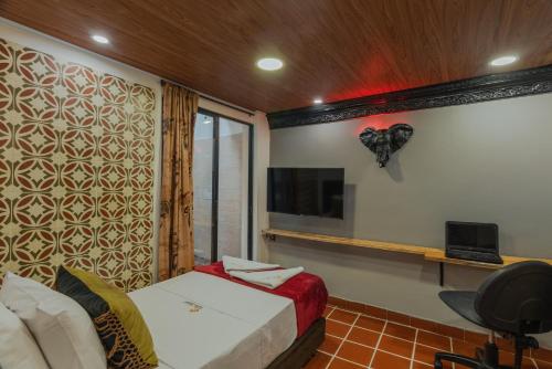 a bedroom with a bed and a tv in a room at Casa Los Naranjos Hostal in Medellín