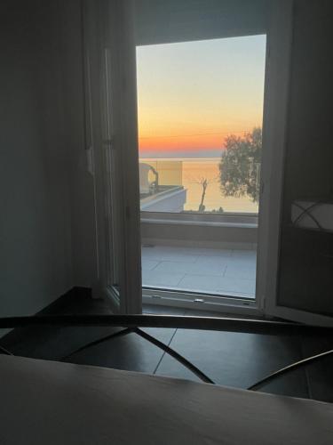 una puerta abierta a un balcón con vistas al océano en Seafront Apartment, en Skala Mistegnon