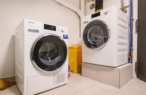 two washing machines sitting next to each other in a laundry room at Günstiges grünes Ferienzimmer mit separater moderner Dusche in Lörrach