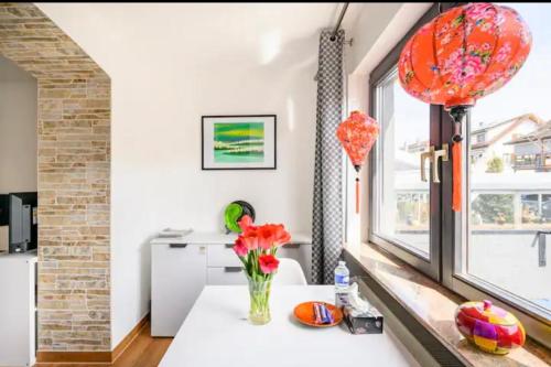 a room with a table with a vase of flowers at Günstiges grünes Ferienzimmer mit separater moderner Dusche in Lörrach