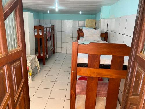 a small room with two bunk beds and a door at A Casa dos Mestres in Salvador