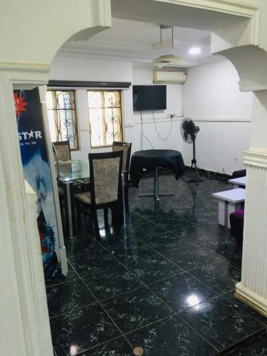 un soggiorno con tavolo e sedie in camera di D Light Hotel ad Abuja