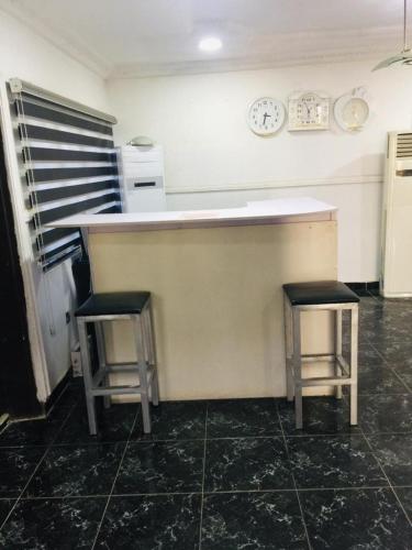 eine Küche mit einer Theke und 2 Hockern in der Unterkunft D Light Hotel in Abuja