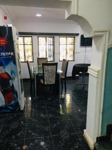 a dining room with a table and chairs and a piano at D Light Hotel in Abuja