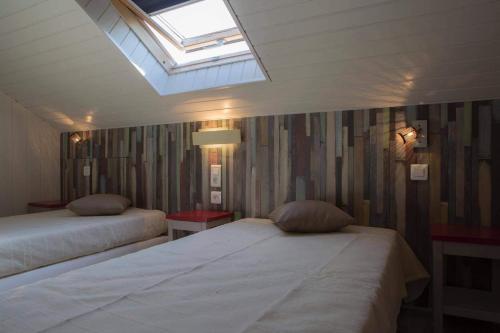 een slaapkamer met 2 bedden en een dakraam bij Chalet l'Arcange 2 a 6 personnes au calme bord riviere Lison Franche Comte in Nans-sous-Sainte-Anne