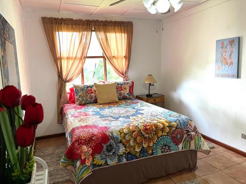 - une chambre avec un lit doté d'une couette colorée et d'une fenêtre dans l'établissement Quizur, Culturita de Paz, à Piedades