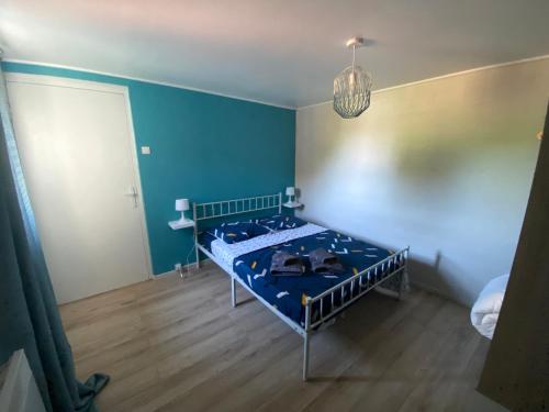 - une chambre avec 2 lits et un mur bleu dans l'établissement Cottage les Écuries, à Béthune