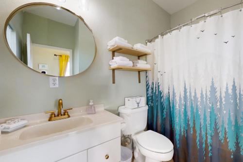 a bathroom with a sink and a toilet and a mirror at This Is It in Crescent City