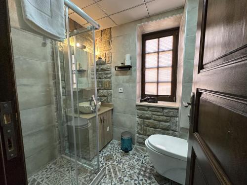 a bathroom with a shower and a toilet and a sink at İLİA BUTİK OTEL in Eceabat