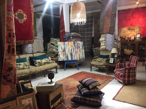 a living room with couches and a tv in it at Hôtel Riad Gnaoua in Essaouira