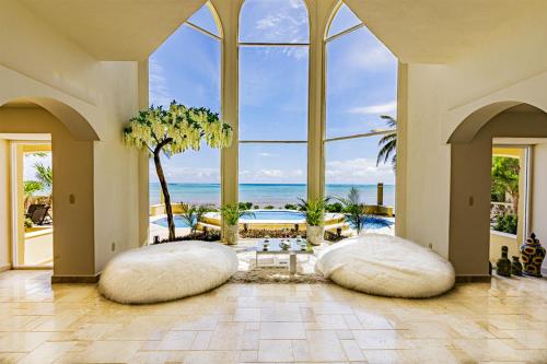 a living room with two large pillows and the ocean at The Oasis Tulum Luxury Front Beach Villa 8 Rooms in Tankah
