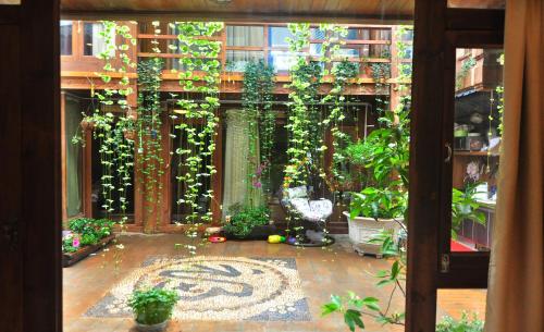 a room with a patio with a lot of plants at Lijiang Old Town Meiliju View Inn in Lijiang