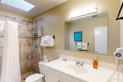 a bathroom with a sink and a toilet and a mirror at Casa Havana @ Duval Square R22 in Key West