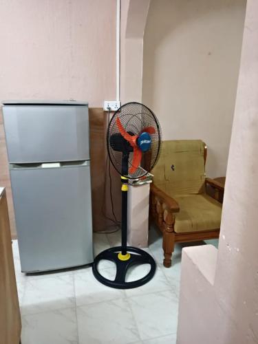 a bird on a fan in a room with a refrigerator at Irolux House. in Quatre Bornes