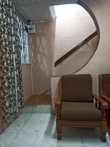 een woonkamer met een stoel en een spiegel bij Irolux House. in Quatre Bornes