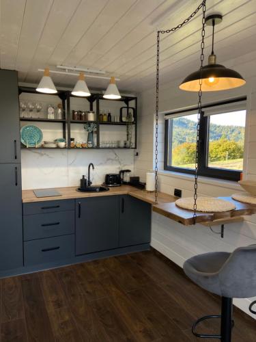 a kitchen with blue cabinets and a counter with a window at Under_sky_slavske in Slavske