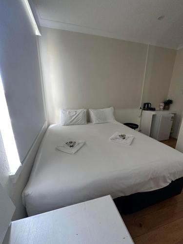 un grande letto bianco in una piccola stanza di Tattersalls Hotel Casino a Casino