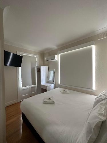 una camera da letto con un grande letto bianco e una finestra di Tattersalls Hotel Casino a Casino