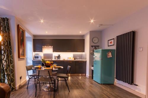 uma cozinha e sala de estar com uma mesa e um frigorífico em Walpole Bay 2 Bed Stunning Garden Apartment em Margate
