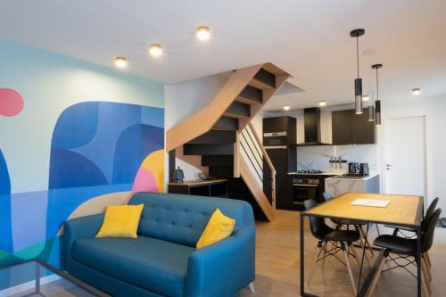 - un salon avec un canapé bleu et un escalier dans l'établissement La Maison de Treminou, à Plomeur