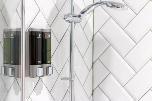 um chuveiro na casa de banho com azulejos brancos em Stylish Home Close To The Beach By Adliv Host em Margate
