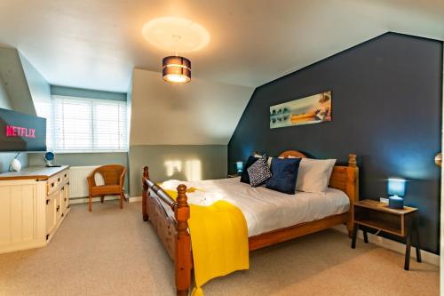 ein Schlafzimmer mit einem großen Bett mit blauer Wand in der Unterkunft Beautiful Margate Coastal Home With Parking in Margate