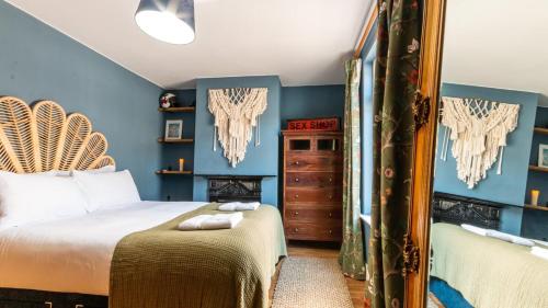um quarto com paredes azuis e uma cama e um espelho em 3-bed Hidden Gem Of A Cottage In Margate em Margate
