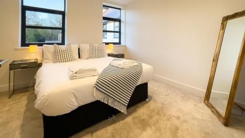 um quarto com uma cama grande e um espelho em Luxury Ocean & North Foreland Golf View Escape em Broadstairs