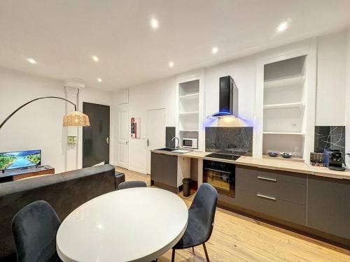 un salon avec une table et des chaises et une cuisine dans l'établissement Cosy appart, Lyon Préfecture Servient 2, à Lyon